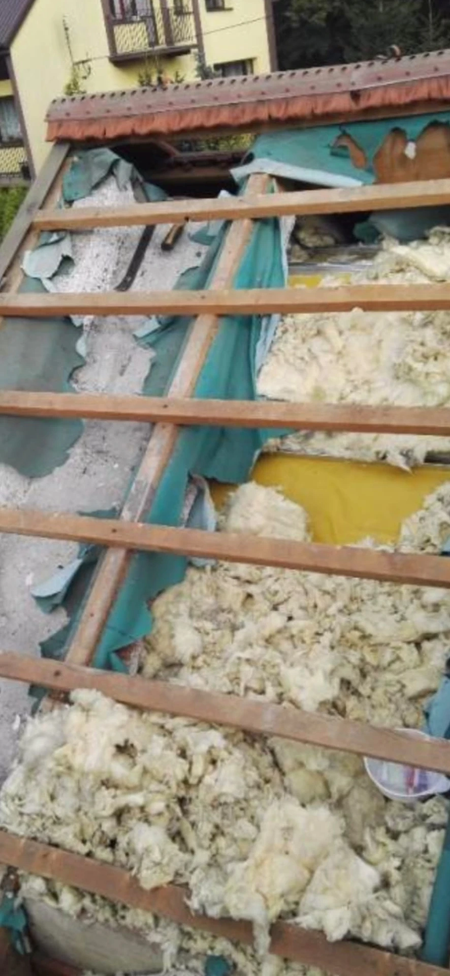 Poddasze z wyciągniętą przez kuny wełną mineralną i zniszczoną membraną